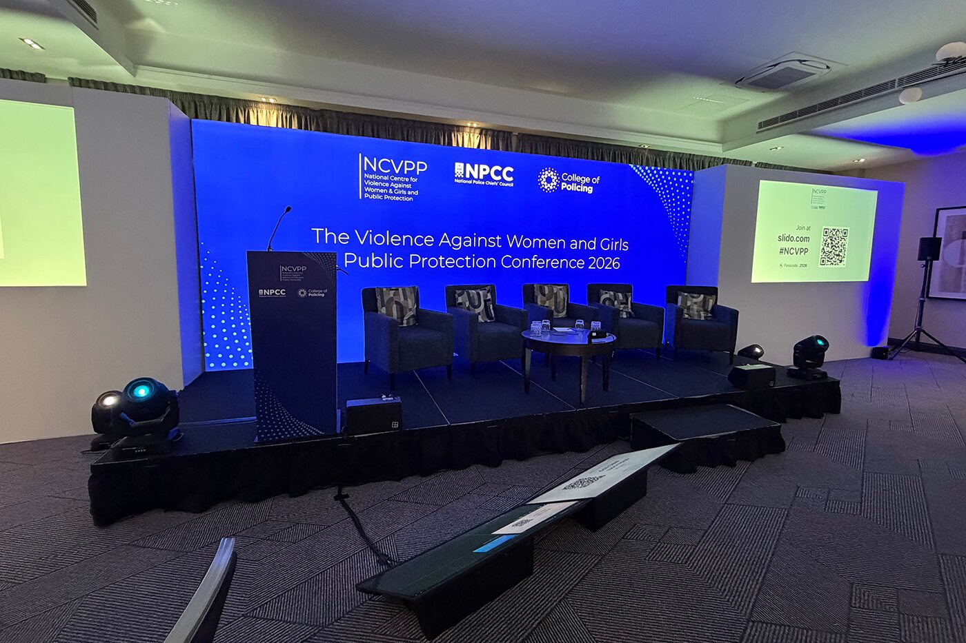 the event production set up for a conference, showing stage, chairs, and backdrop